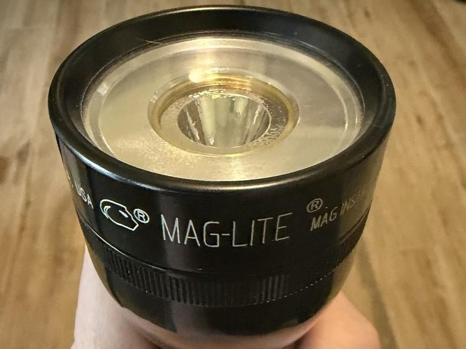Close-up of the head and reflector of a black Maglite® flashlight